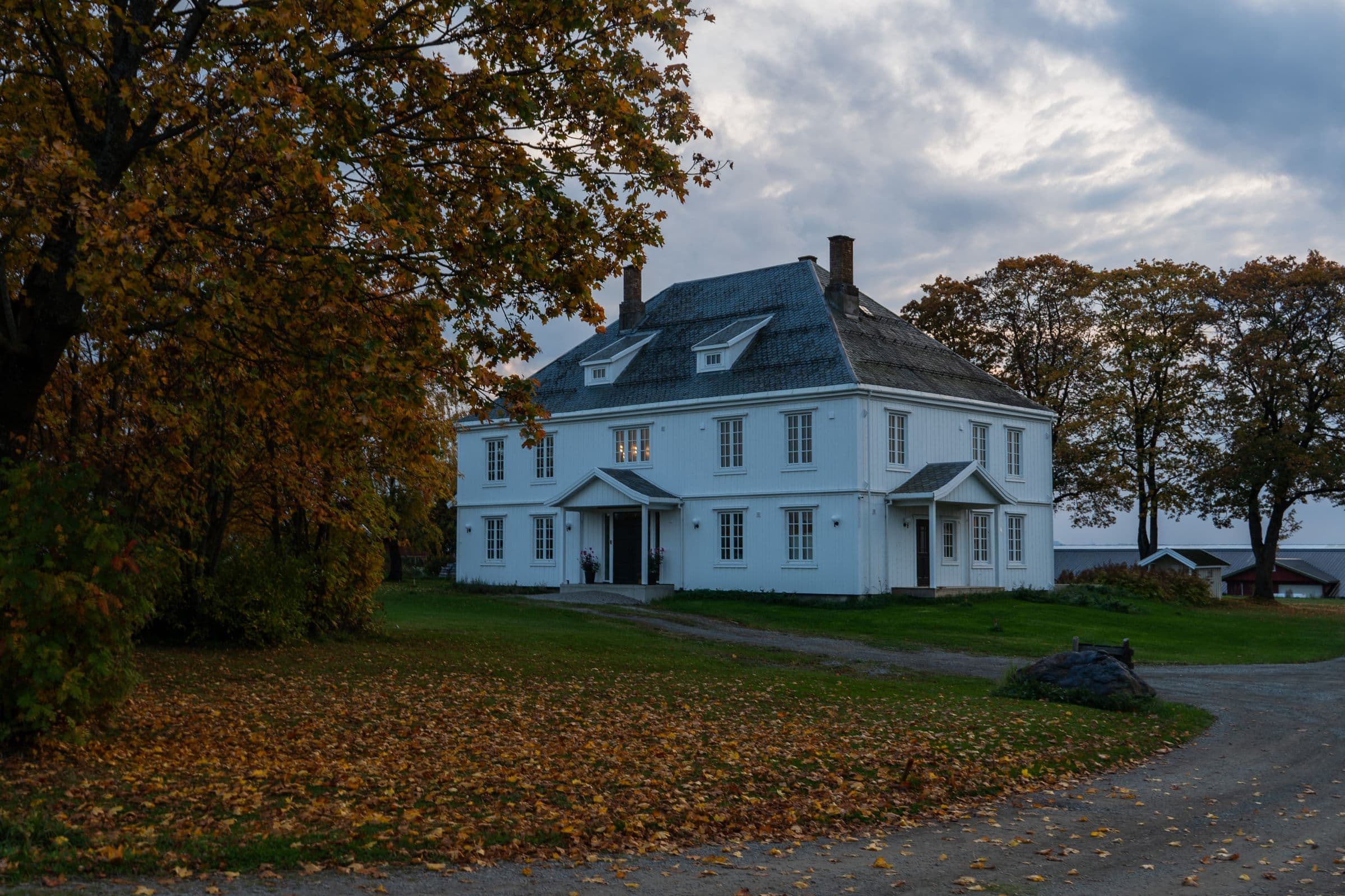 A white historic house with autumn leaves in Dorchester, NB where we do junk removal